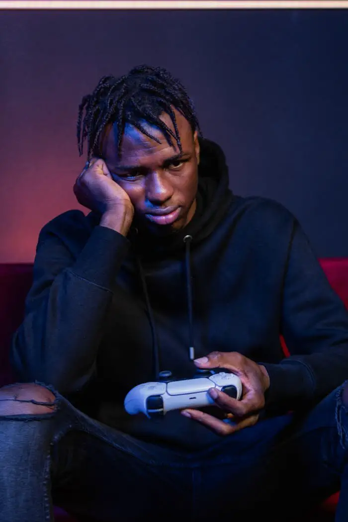 A Man in Black Hoodie Jacket Sitting while Holding a Game Controller